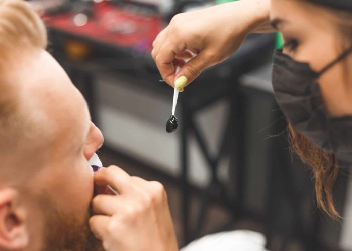 beard modeling in Barber shop, removing hair from the nose and ears with wax, male beauty and care concept