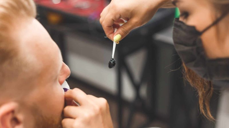 beard modeling in Barber shop, removing hair from the nose and ears with wax, male beauty and care concept