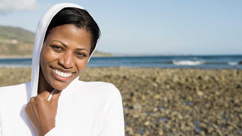 Smiling woman on a shingle beach